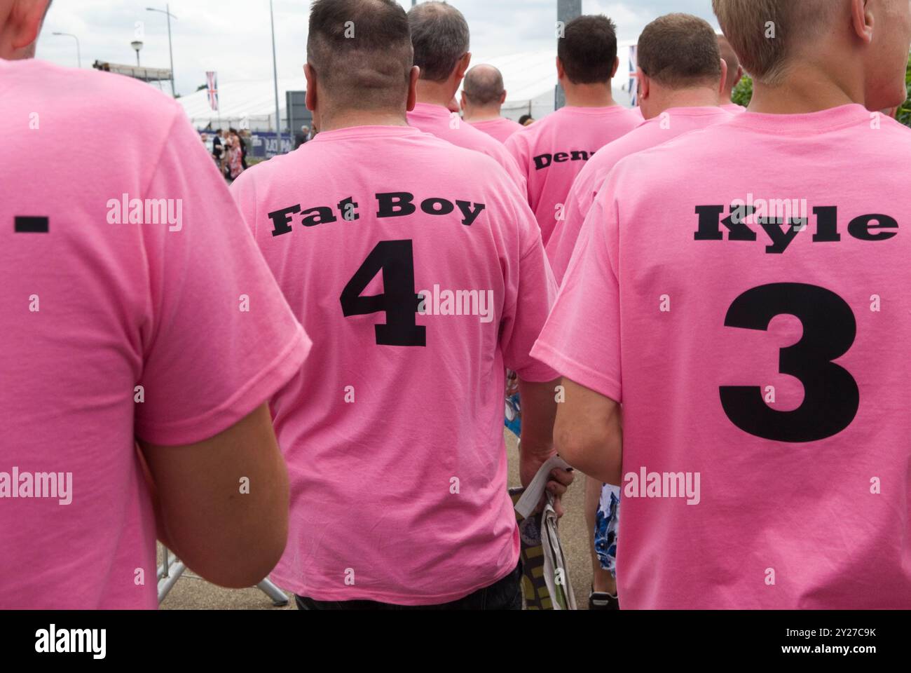 È richiesto un abbigliamento da fare a Mans Stag. Abbigliamento personalizzato per feste di addio al celibato, i nomi dei partecipanti sono stampati sul retro delle magliette rosa. Gli uomini si riuniscono solo al Derby. Epsom Down, Surrey Inghilterra 2012 UK 2010s HOMER SYKES. Foto Stock