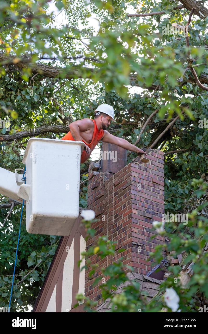 Detroit, Michigan - Un operaio smonta un camino di mattoni dopo che una tempesta con raffiche di vento a 70 km/h ha fatto esplodere una cottonwood da 15 tonnellate e 110 piedi. L'albero si è rotto Foto Stock