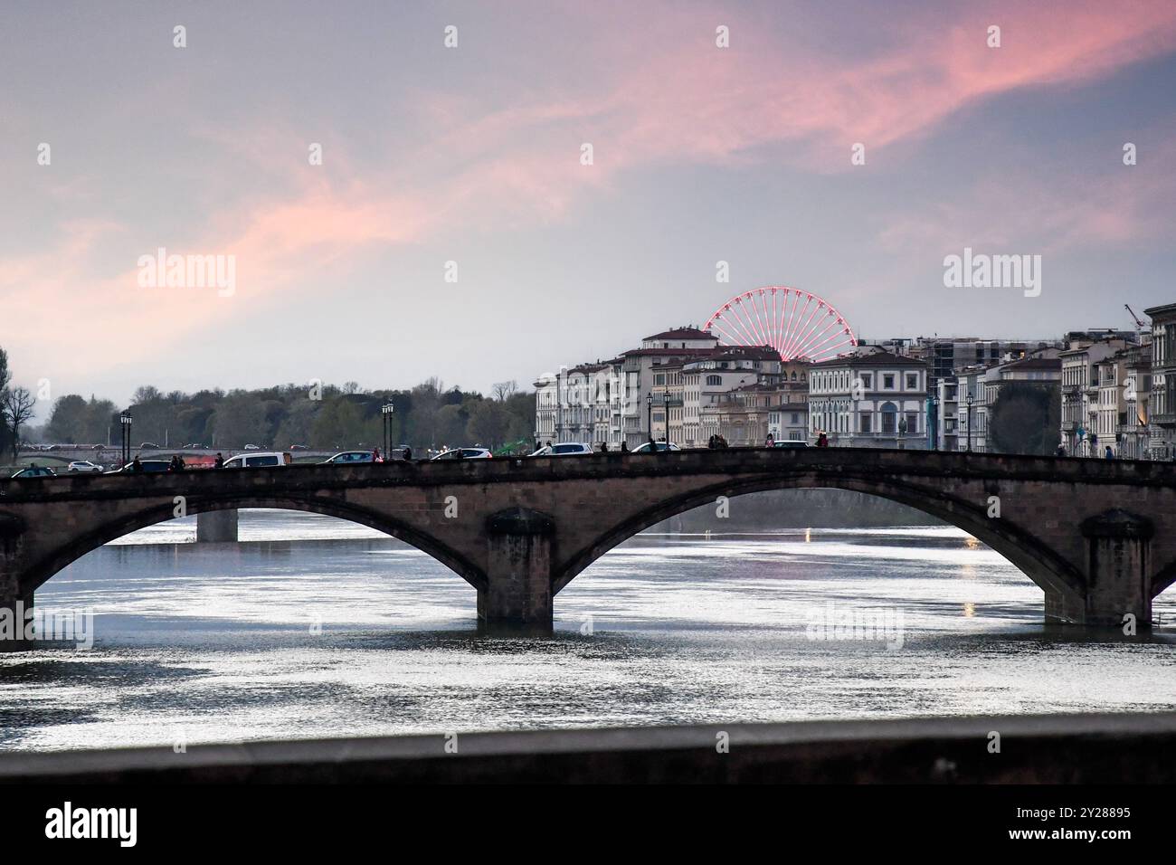 Vista del fiume Arno con il Ponte alla Carraia e la ruota panoramica sullo sfondo al tramonto, Firenze, Toscana, Italia Foto Stock