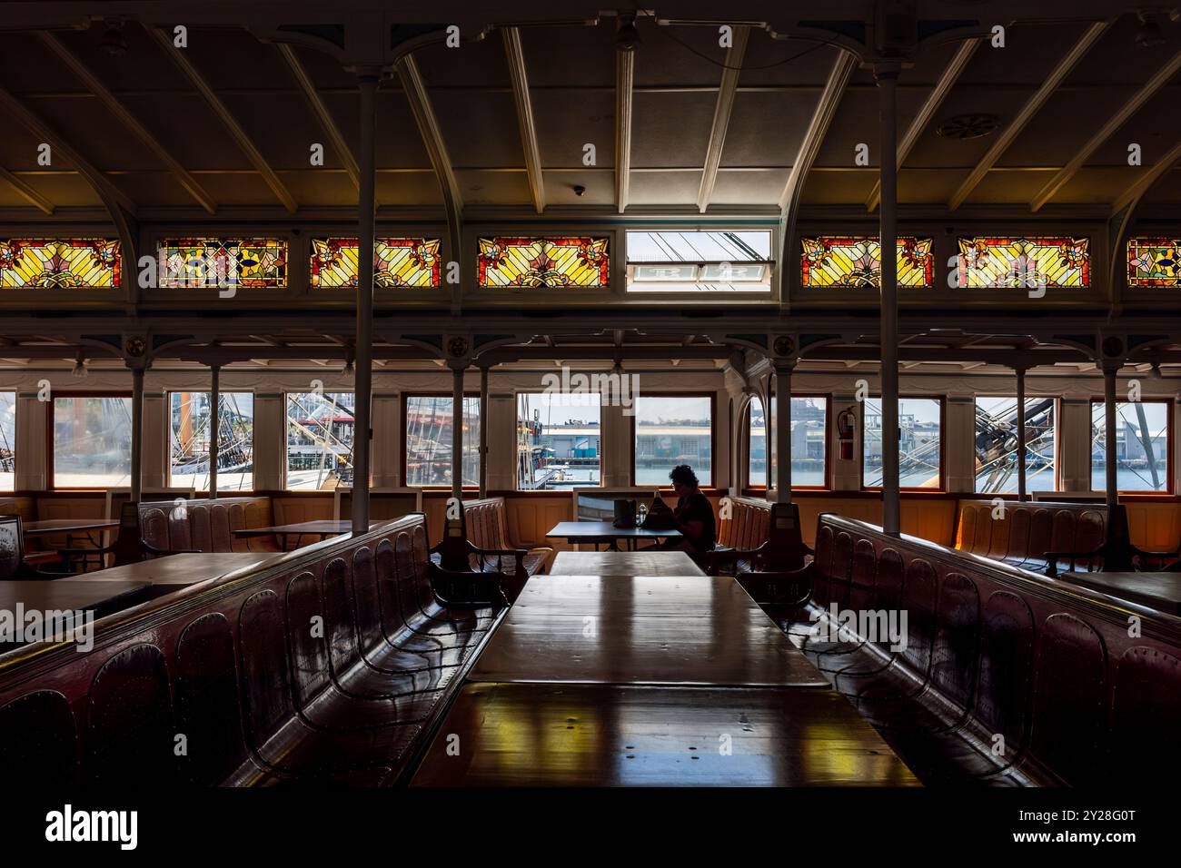 Una figura solitaria seduta a bordo dello storico traghetto a vapore della Baia di San Francisco, Berkeley ormeggiata al Maritime Museum di San Diego, California Foto Stock