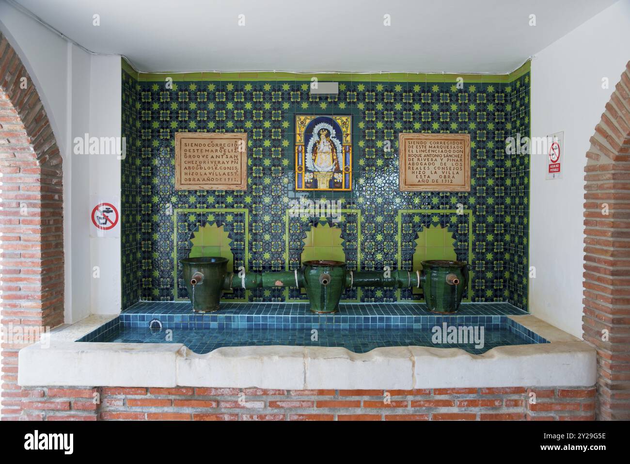 Interni decorati con mosaico blu e diversi rubinetti, adornati con simboli religiosi e iscrizioni spagnole, Fuente del Pilar grande, Canillas de Foto Stock