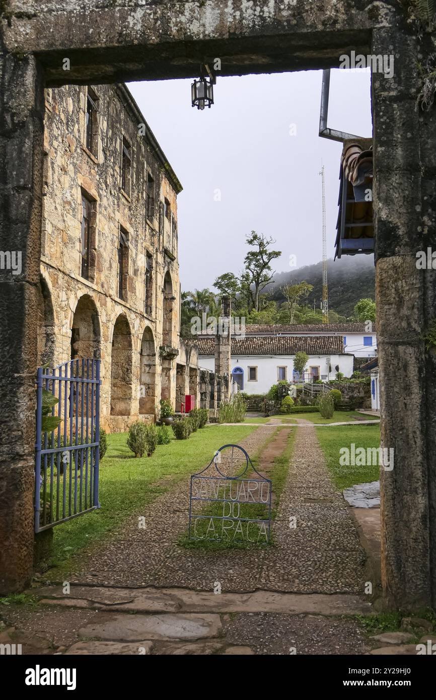 Ammira attraverso un cancello d'ingresso di stoney lo storico museo restaurato del Santuario di Caraca con archi e finestre, Minas Gerais, Brasile, Sud America Foto Stock