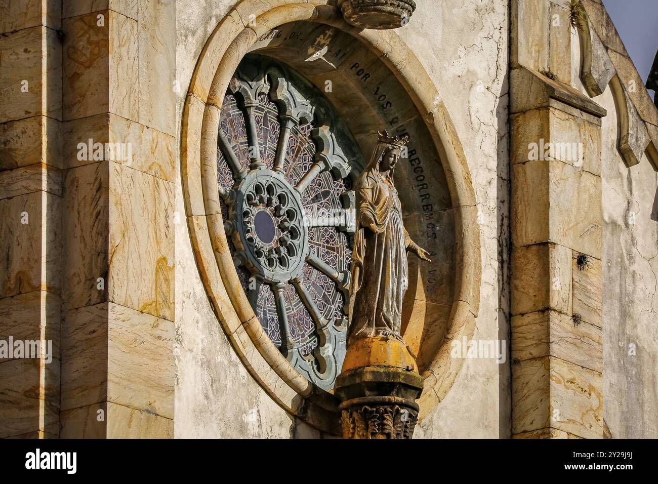 Vista laterale della statua di un santo di fronte a una finestra rotonda della chiesa al sole, Santuario di Caraca, Minas Gerais, Brasile, Sud America Foto Stock