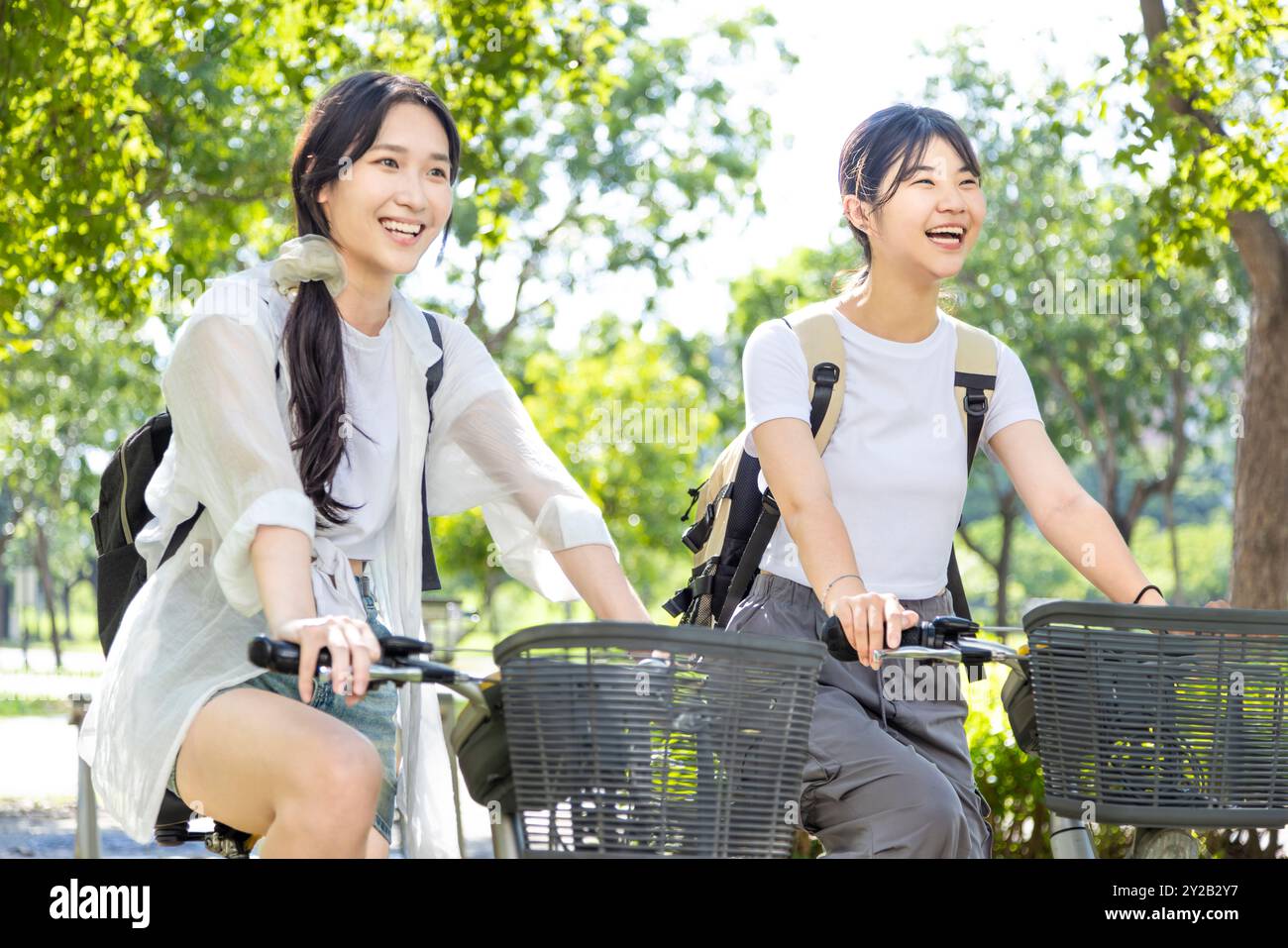 Ragazze felici che vanno in bicicletta e vanno a scuola Foto Stock