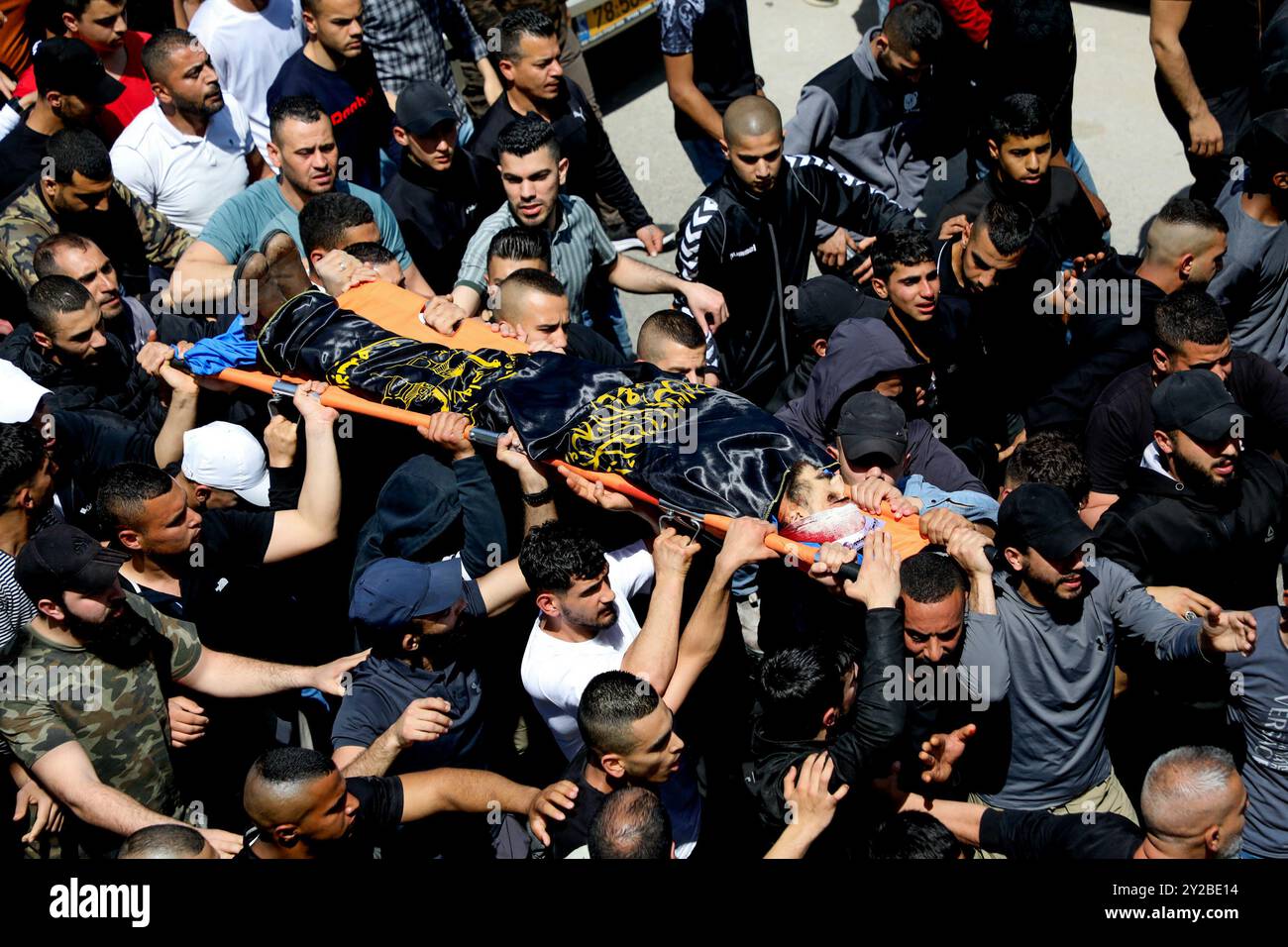 Jenin, Cisgiordania, Palestina. 9 aprile 2022. I palestinesi nel campo profughi di Jenin, nella Cisgiordania settentrionale, trasportano il corpo di Ahmad al-Saadi, 23 anni, ucciso durante un raid israeliano su larga scala sul campo profughi di Jenin nella Cisgiordania settentrionale. Si ritiene che al-Saadi sia stato affiliato al movimento della Jihad islamica palestinese. Almeno altri 13 palestinesi hanno subito ferite da proiettile, tra cui una donna di 19 anni, durante i pesanti scontri avvenuti durante il raid. Il raid segue l'uccisione da parte dei soldati israeliani di venerdì di Raad Hazem, 28 anni, presumibilmente dietro a una sparatoria letale Foto Stock