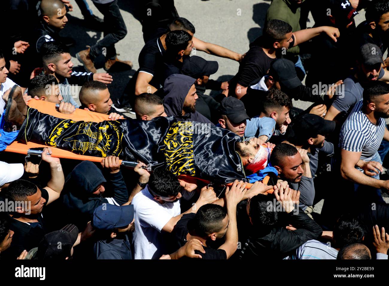 Jenin, Cisgiordania, Palestina. 9 aprile 2022. I palestinesi nel campo profughi di Jenin, nella Cisgiordania settentrionale, trasportano il corpo di Ahmad al-Saadi, 23 anni, ucciso durante un raid israeliano su larga scala sul campo profughi di Jenin nella Cisgiordania settentrionale. Si ritiene che al-Saadi sia stato affiliato al movimento della Jihad islamica palestinese. Almeno altri 13 palestinesi hanno subito ferite da proiettile, tra cui una donna di 19 anni, durante i pesanti scontri avvenuti durante il raid. Il raid segue l'uccisione da parte dei soldati israeliani di venerdì di Raad Hazem, 28 anni, presumibilmente dietro a una sparatoria letale Foto Stock