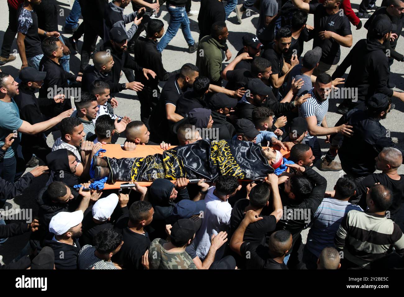 Jenin, Cisgiordania, Palestina. 9 aprile 2022. I palestinesi nel campo profughi di Jenin, nella Cisgiordania settentrionale, trasportano il corpo di Ahmad al-Saadi, 23 anni, ucciso durante un raid israeliano su larga scala sul campo profughi di Jenin nella Cisgiordania settentrionale. Si ritiene che al-Saadi sia stato affiliato al movimento della Jihad islamica palestinese. Almeno altri 13 palestinesi hanno subito ferite da proiettile, tra cui una donna di 19 anni, durante i pesanti scontri avvenuti durante il raid. Il raid segue l'uccisione da parte dei soldati israeliani di venerdì di Raad Hazem, 28 anni, presumibilmente dietro a una sparatoria letale Foto Stock