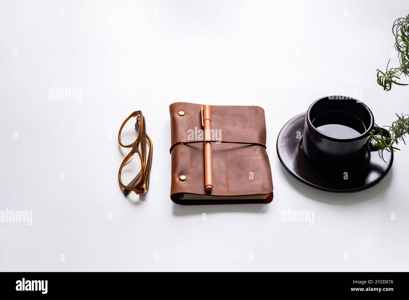 Oggetti essenziali per l'ufficio con tazza da caffè, bicchieri, notebook e pianta su una scrivania bianca. Foto Stock Oggetti essenziali per l'ufficio con tazza da caffè, bicchieri, notebook e pianta su una scrivania bianca. Foto Stock