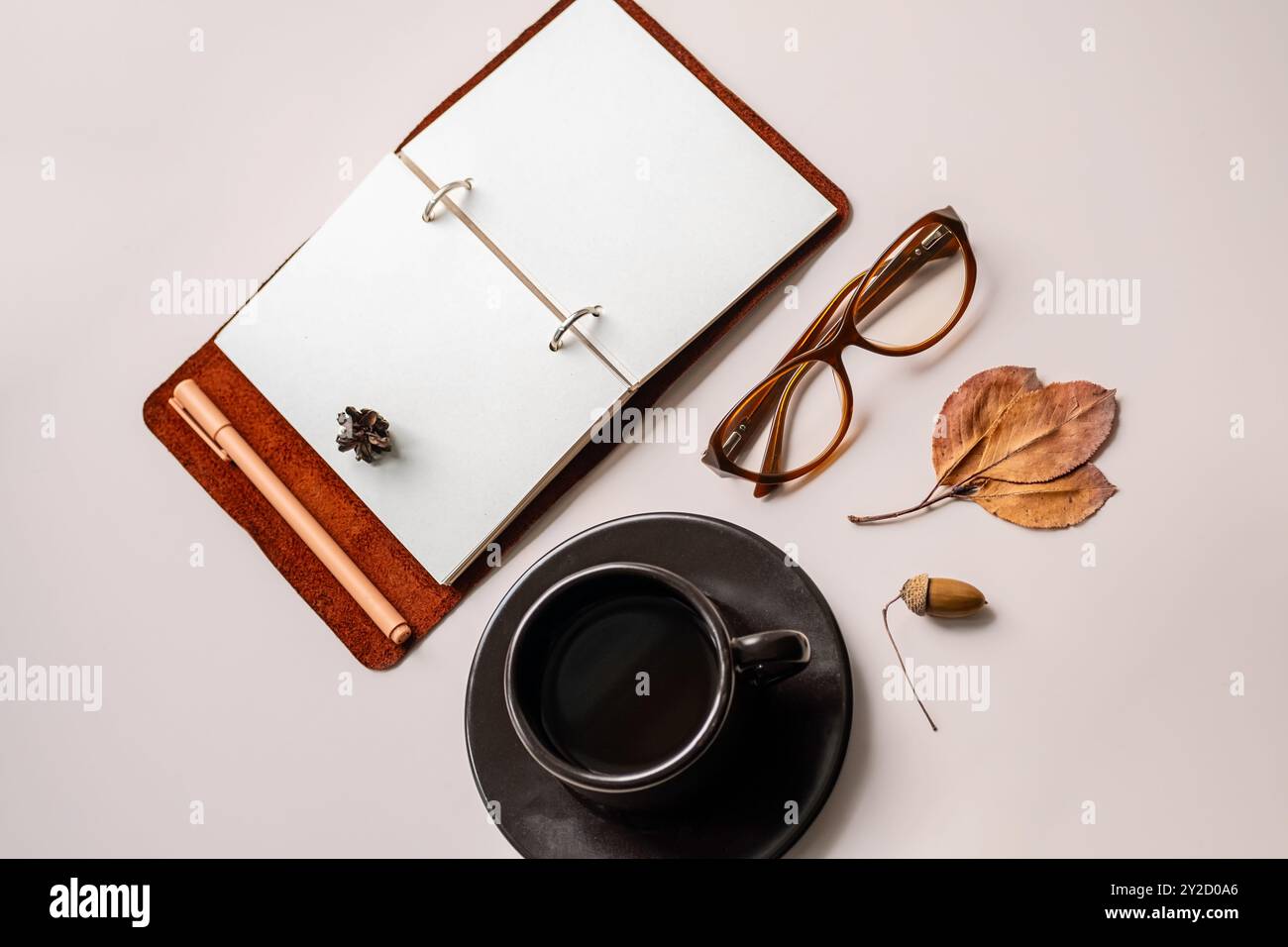 Spazio di lavoro minimalista con notebook aperto, bicchieri e tazze da caffè. Foto Stock