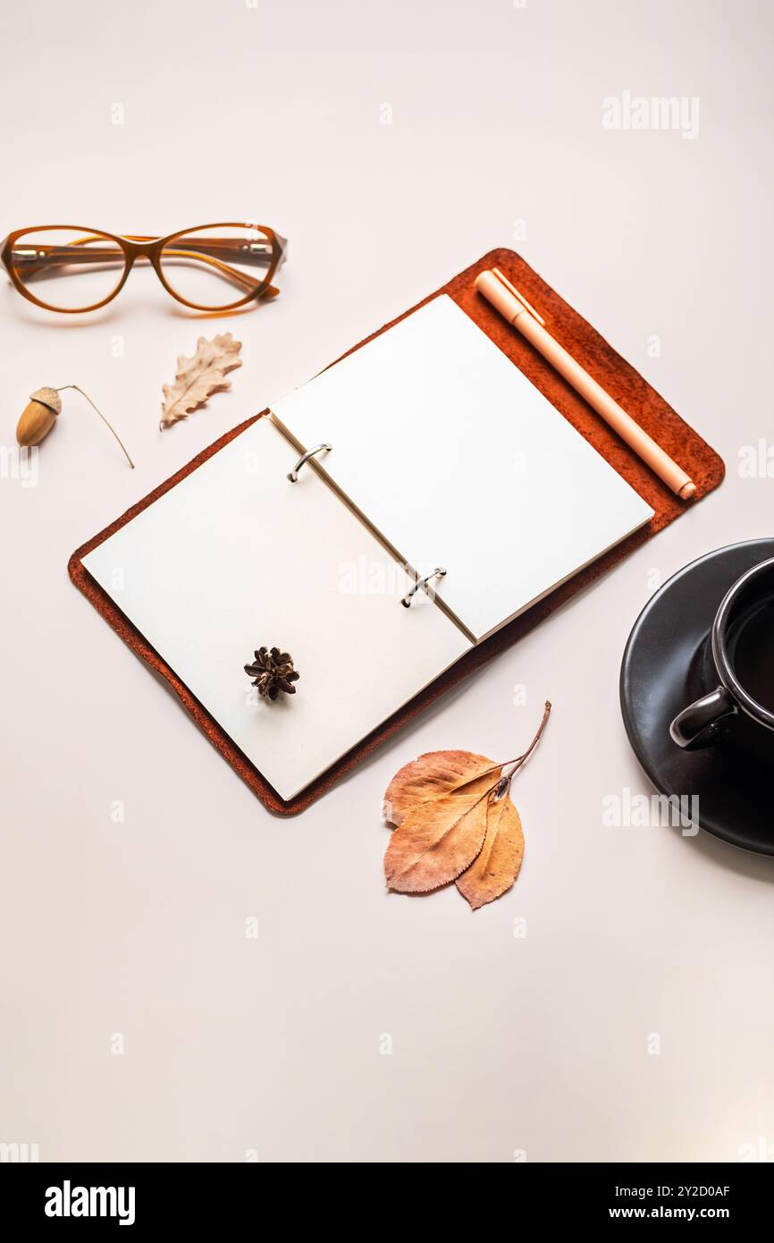 Spazio di lavoro minimalista con notebook aperto, bicchieri e tazze da caffè. Foto Stock