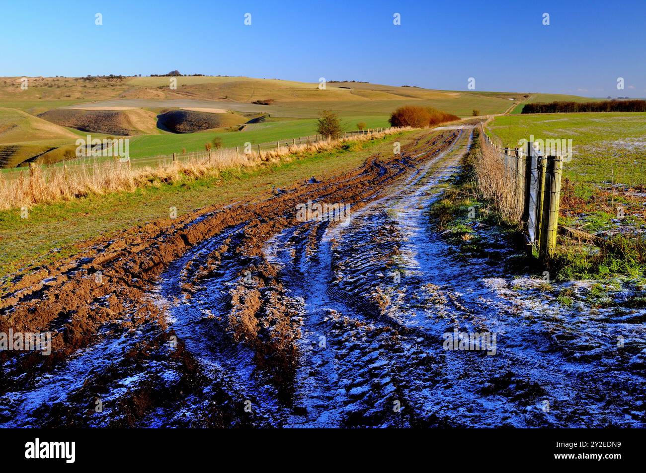 Frozen ha solcato tracce lungo una strada pubblica sul Wiltshire Downs. Foto Stock