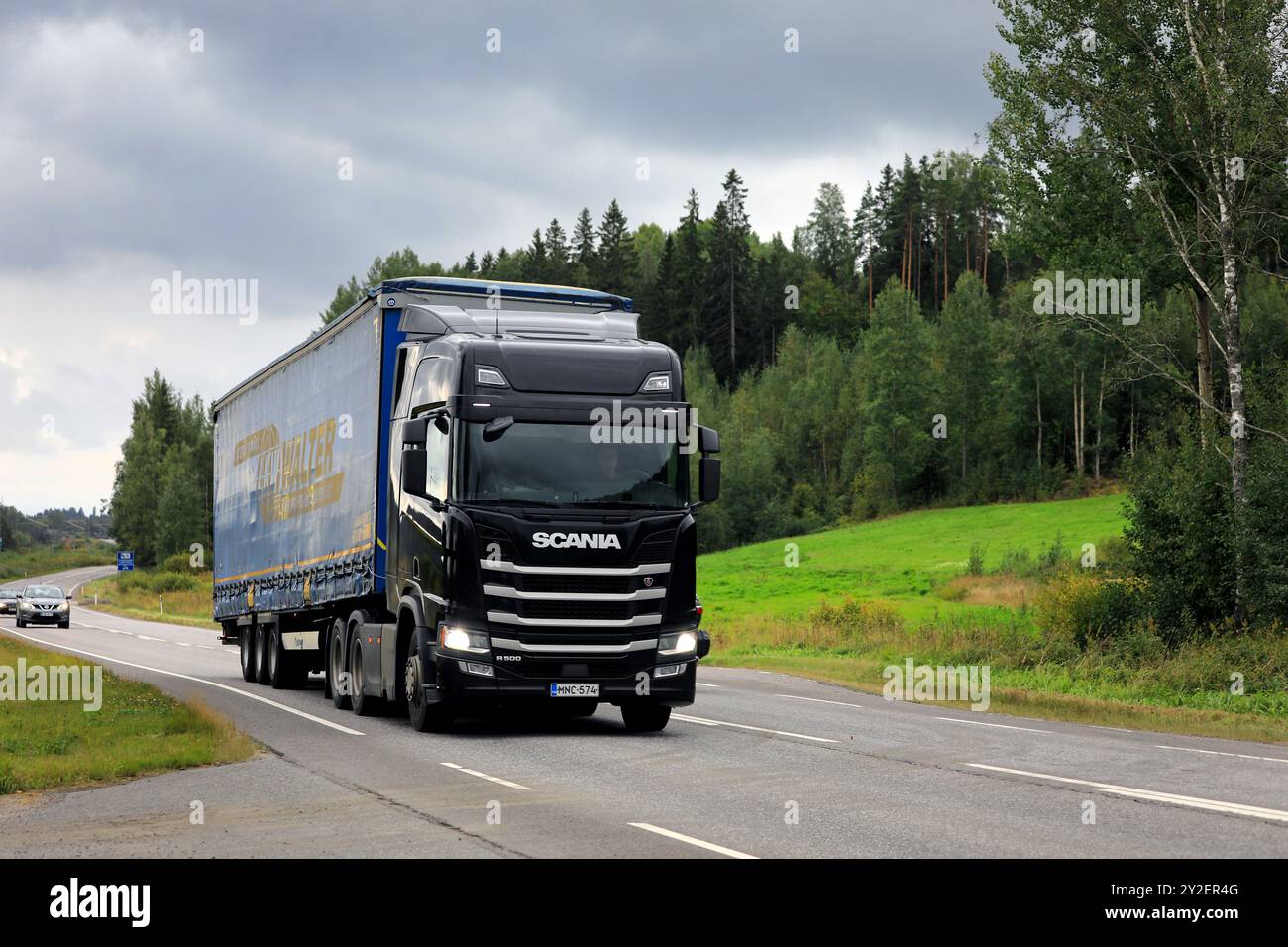 Il semirimorchio Scania R500 nero trasporta merci lungo l'autostrada sotto il cielo coperto. Salo, Finlandia. 23 agosto 2024. Foto Stock