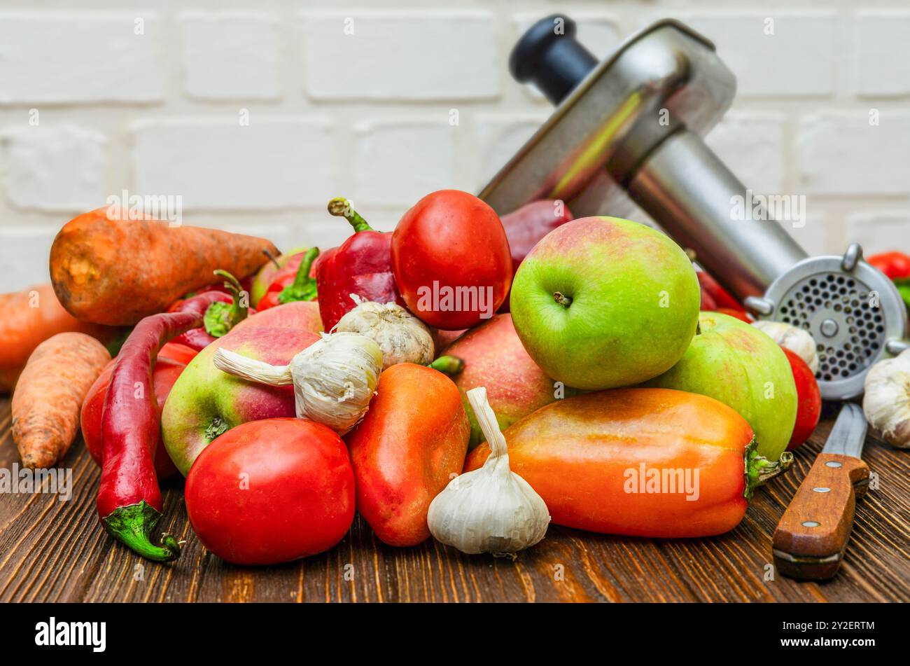 Pomodori, mele, peperoni e macinacaffè - processo di preparazione della salsa calda Foto Stock