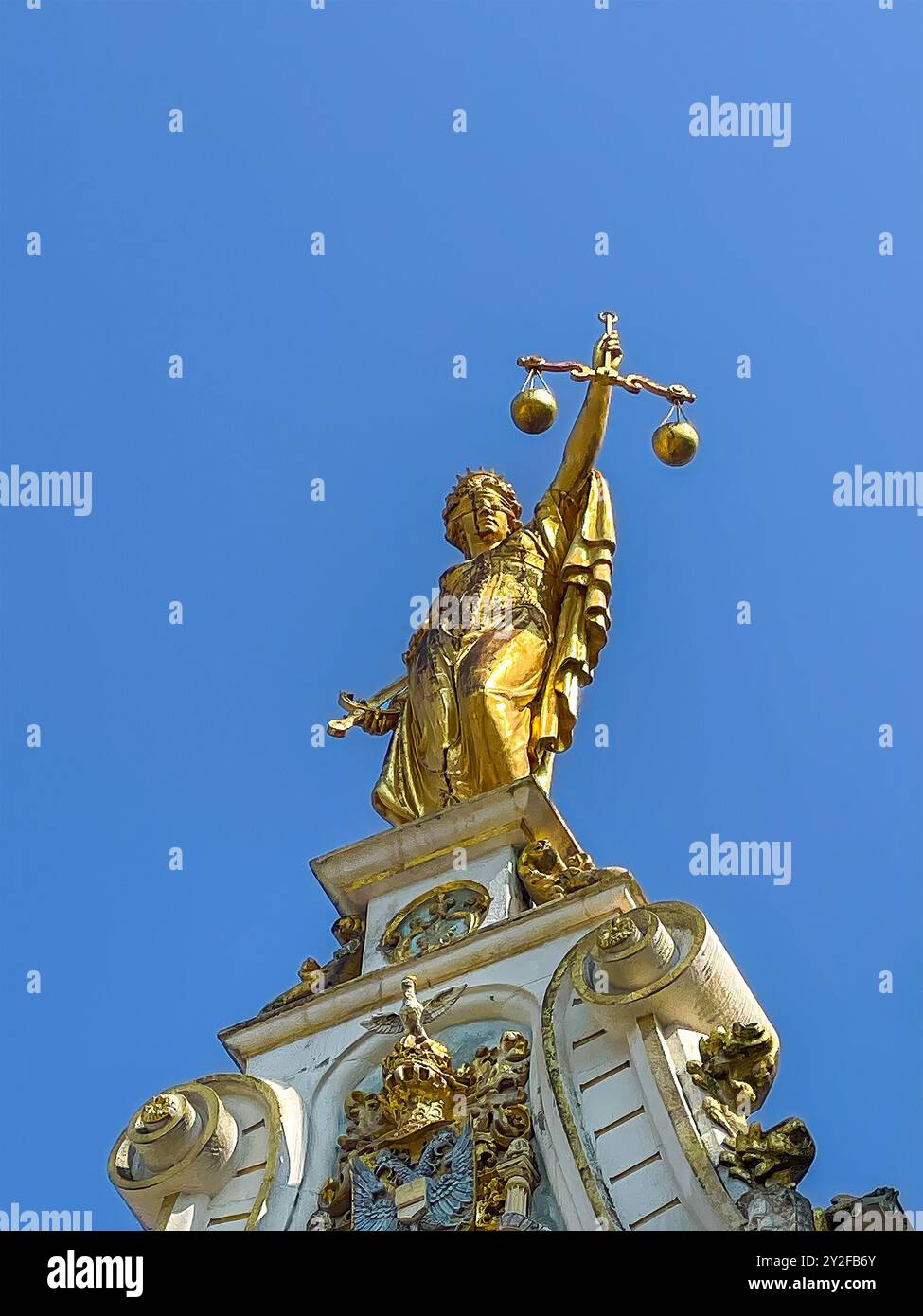 Bruges, Fiandre, Belgio - 25 giugno 2024: Primo piano, statua della Signora d'Oro della giustizia in cima alla storica Corte di giustizia in Piazza Burg, contro il cielo blu Foto Stock