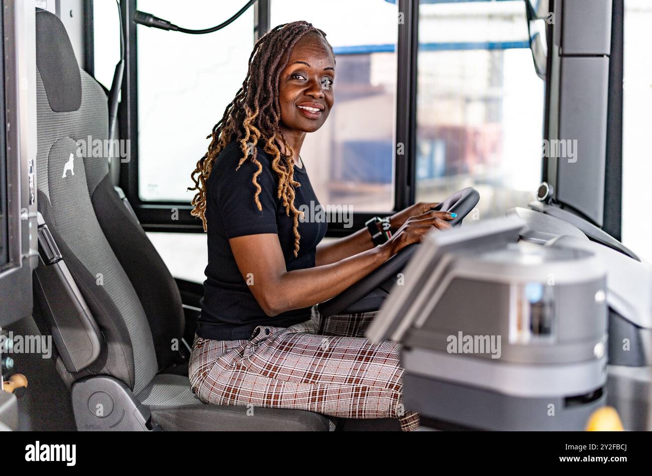 Flensburg, Germania. 10 settembre 2024. L'autista di autobus keniota Millicent Awiti è seduto al volante di un autobus presso il deposito di Flensburg. Il ministro dei trasporti dello Schleswig-Holstein Madsen (CDU) e l'ambasciatore keniota Mokaya Orina hanno dato il benvenuto ai cinque futuri conducenti di autobus del Kenya. Lavoreranno quindi per "Aktiv Bus Flensburg". Credito: Axel Heimken/dpa/Alamy Live News Foto Stock