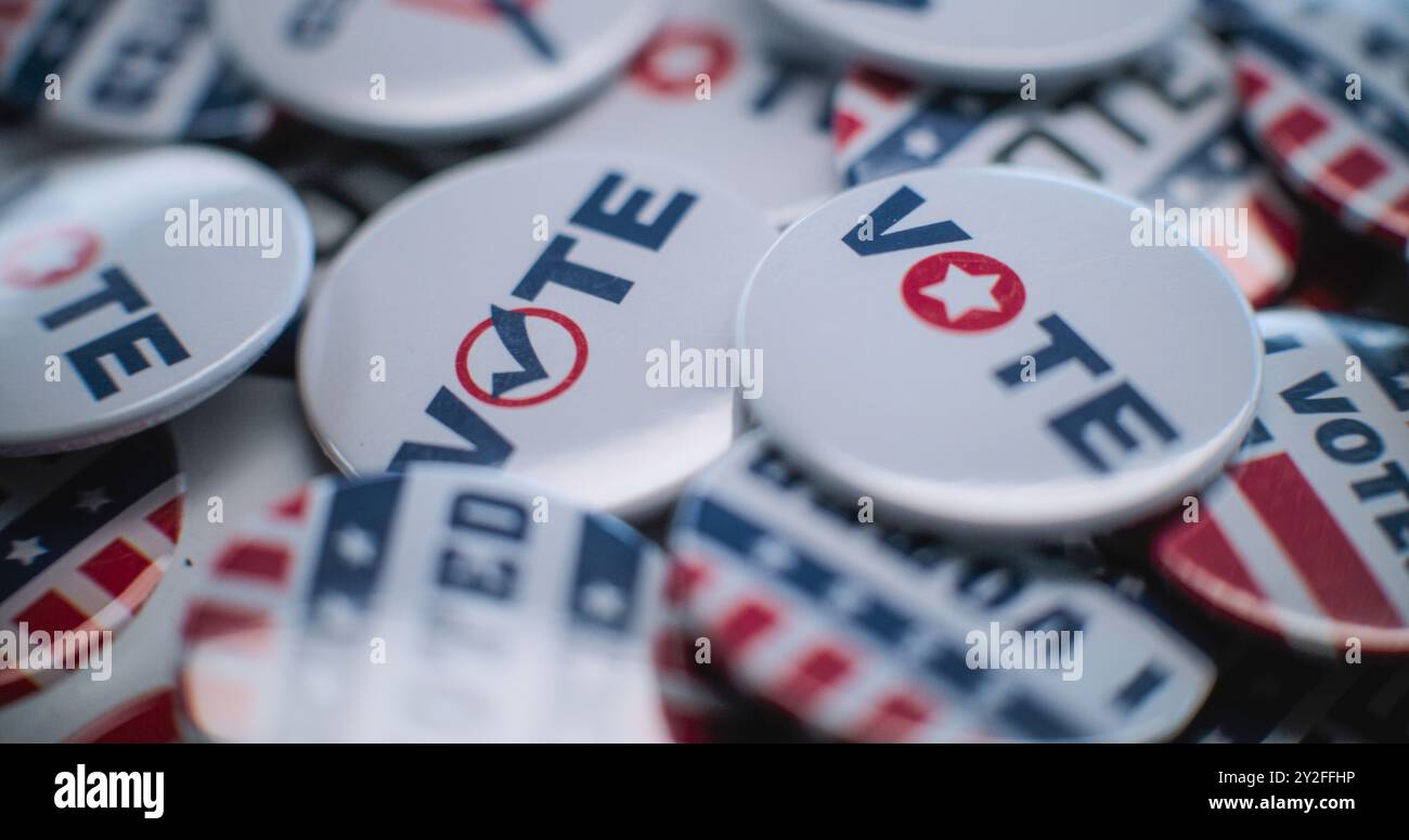 Primo piano di distintivi patriottici con il logo e l'iscrizione della bandiera americana. Elezioni presidenziali negli Stati Uniti d'America. Copertura elettorale e della razza politica. Concetto di democrazia e patriottismo. Foto Stock