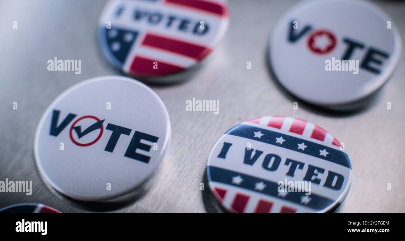 Primo piano di distintivi patriottici con il logo e l'iscrizione della bandiera americana. Elezioni presidenziali negli Stati Uniti d'America. Copertura elettorale e della razza politica. Concetto di democrazia e patriottismo. Foto Stock