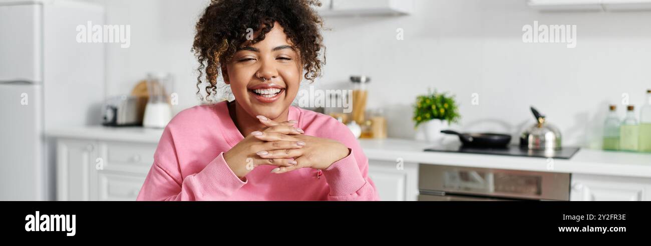 Una donna sorridente abbraccia un momento allegro mentre si rilassa a casa. Foto Stock