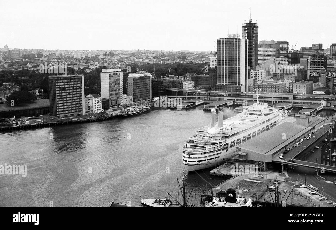 AJAXNETPHOTO. 1964. SYDNEY, AUSTRALIA. - CIRCULAR QUAY - ATTRAVERSATE IL TRAGHETTO DEL PORTO E IL TERMINAL DELLE NAVI DA CROCIERA INTERNAZIONALI E PASSEGGERI CON P&O LINES CANBERRA ORMEGGIATA SULLA DESTRA. AMP (AUSTRALIAN MUTUAL PROVIDENT) SOCIETY TOWER SI TROVA AL CENTRO, SOPRA CANBERRA. FOTO: JONATHAN EASTLAND/AJAX RIF:243602 35 111 Foto Stock