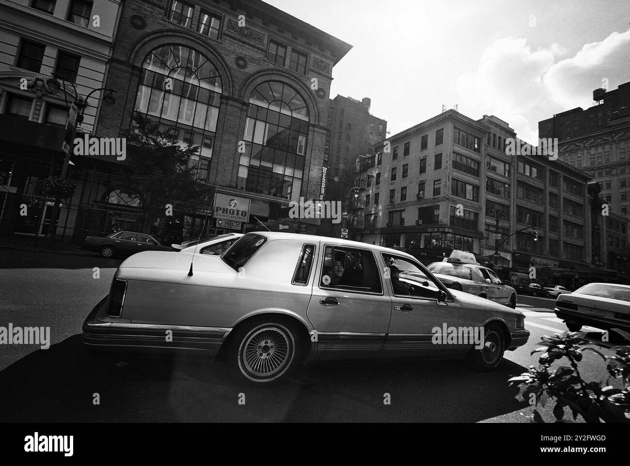 AJAXNETPHOTO. 2000. MANHATTAN, NEW YORK, STATI UNITI. - AMERICAN CLASSIC - 1990 LINCOLN CITY CAR SEDAN PASSANDO 339 EDIFICIO DEMAREST SULLA 5TH AVE VICINO ALL'ANGOLO DI EAST 33RD STREET REAR PASSENGER RUBBERNECKING. EDIFICIO DEMAREST PROGETTATO DALL'ARCHITETTO JAMES RENWICK JR. DI RENWICK ASPINALL & RUSSELL NEL 1890. ORA (2024) DEMOLITO. FOTO: JONATHAN EASTLAND/AJAXREF: 3547BW 03 7A Foto Stock