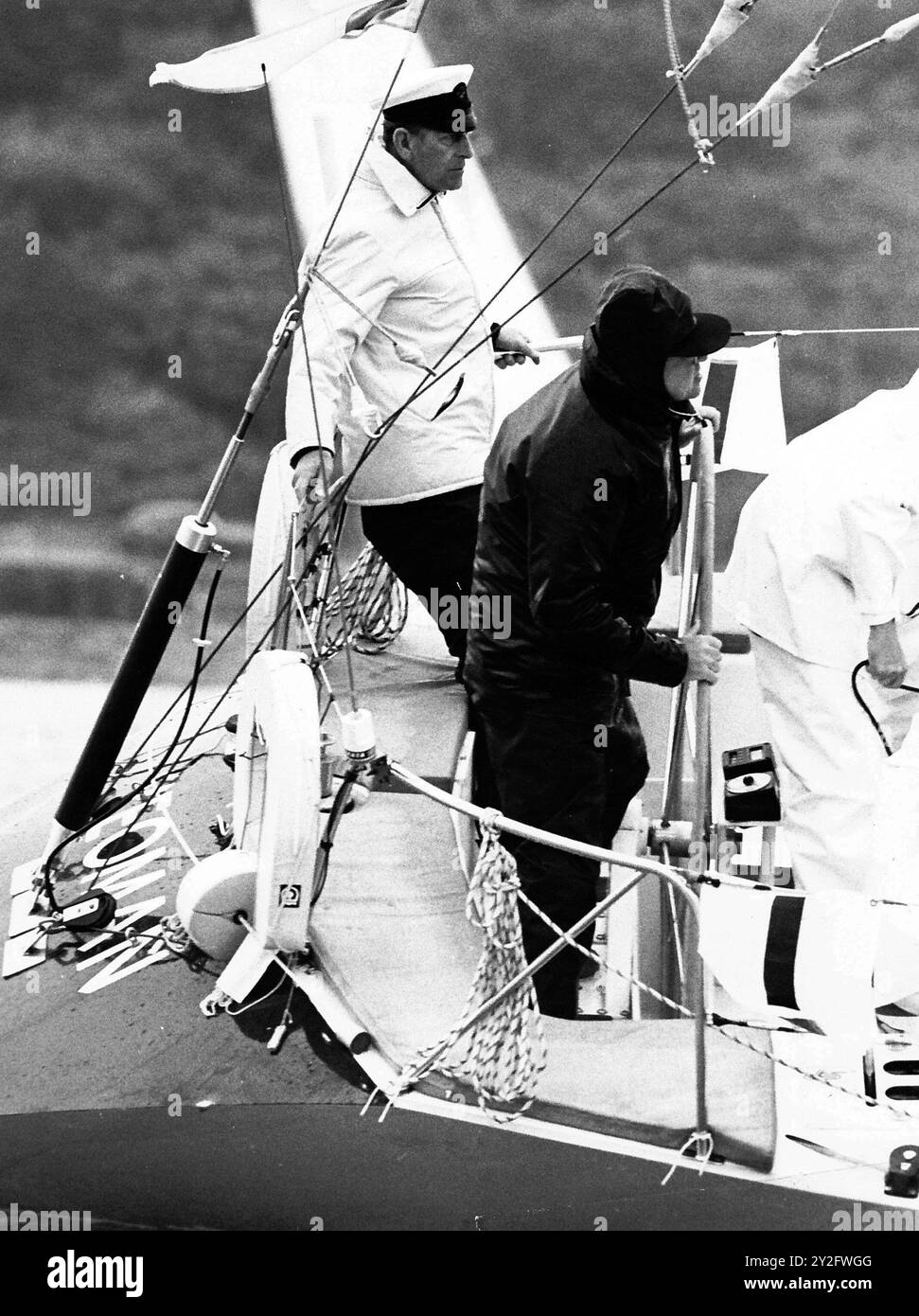 AJAXNETPHOTO. AGOSTO 1985. COWES, ENGLAND-DUKE VEDE L'AZIONE - IL PRINCIPE FILIPPO IL DUCA DI EDIMBURGO ARROCCATO IN ALTO NELLE LENZUOLA STERN DI OWEN AISHER'S YEOMAN TWENTY SIX (XXVI) ALL'INIZIO DELLA GARA DI BRITANNIA CUP DURANTE LA COWES WEEK REGATTA. FOTO;JONATHAN EASTLAND/AJAX RIF:860308 MX340 241408 29 Foto Stock