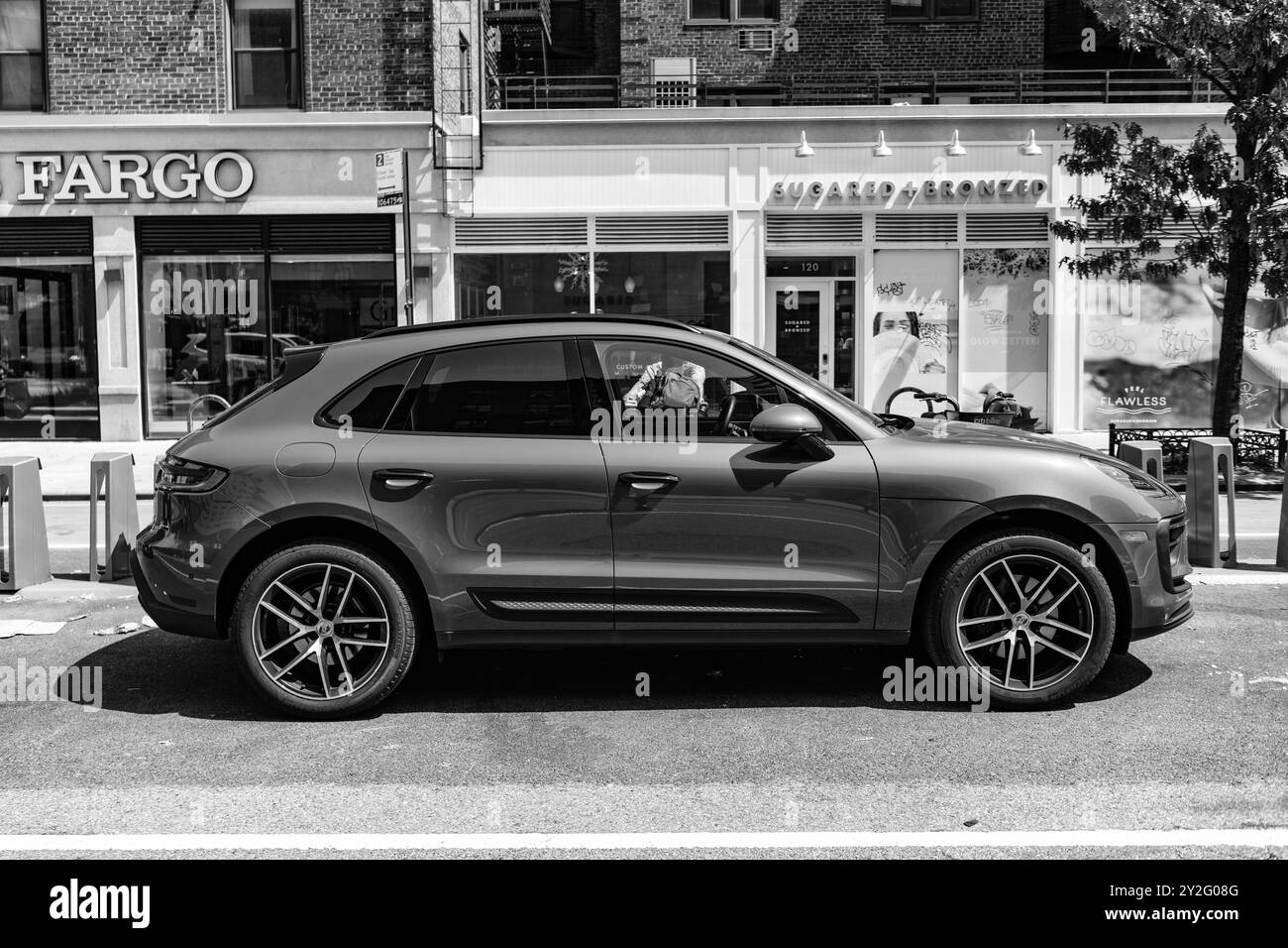 New York City, USA - 5 agosto 2023: 2023 Porsche Macan T SUV rosso rubino, vista lato passeggero, parcheggiato Foto Stock