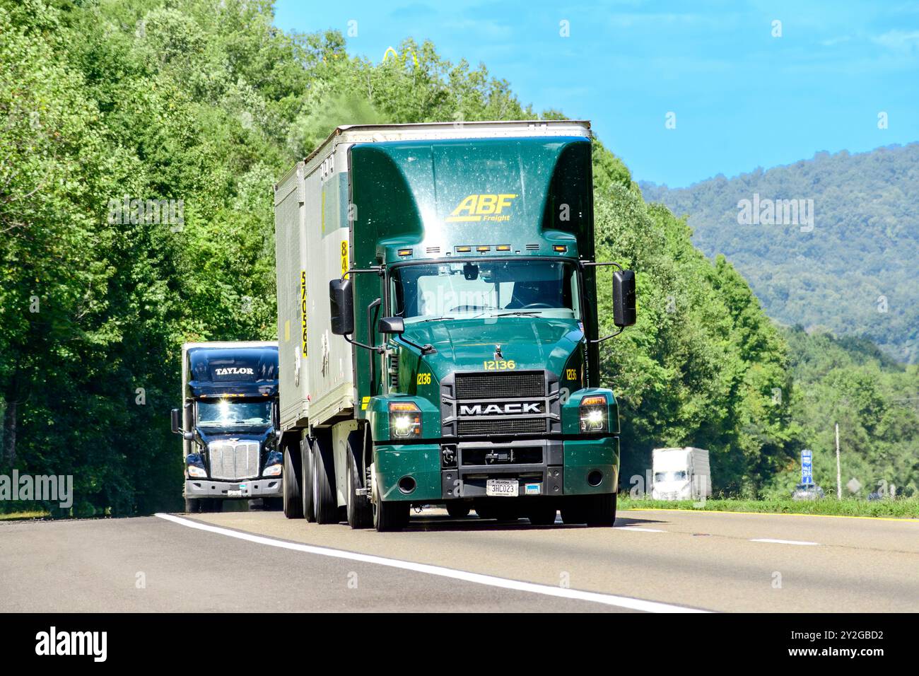 Knoxville, Tennessee, Stati Uniti – 20 agosto 2024: Ripresa orizzontale di un semirimorchio verde su un'autostrada interstatale. Ondate di calore in aumento Foto Stock