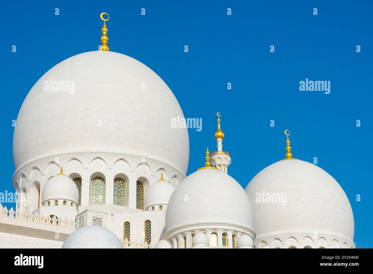 Le cupole della grande Moschea dello sceicco Zayed ad Abu Dhabi, negli Emirati Arabi Uniti, una delle moschee più grandi del mondo contro il cielo blu. Cupole in marmo bianco di arte islamica e. Foto Stock