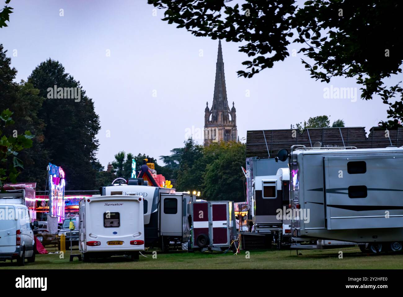 Dietro le quinte di una fiera itinerante con rimorchi e veicoli parcheggiati su un campo a Saffron Walden, Essex, Regno Unito Foto Stock