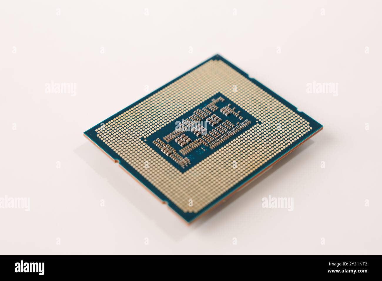 Primo piano del retro di un processore per computer con piedini, isolati su sfondo bianco Foto Stock