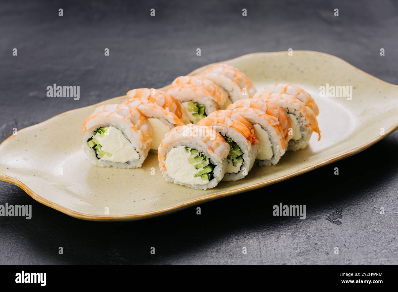 Involtini di sushi ai gamberi Philadelphia con ripieno cremoso e cetriolo, piatti della cucina giapponese Foto Stock