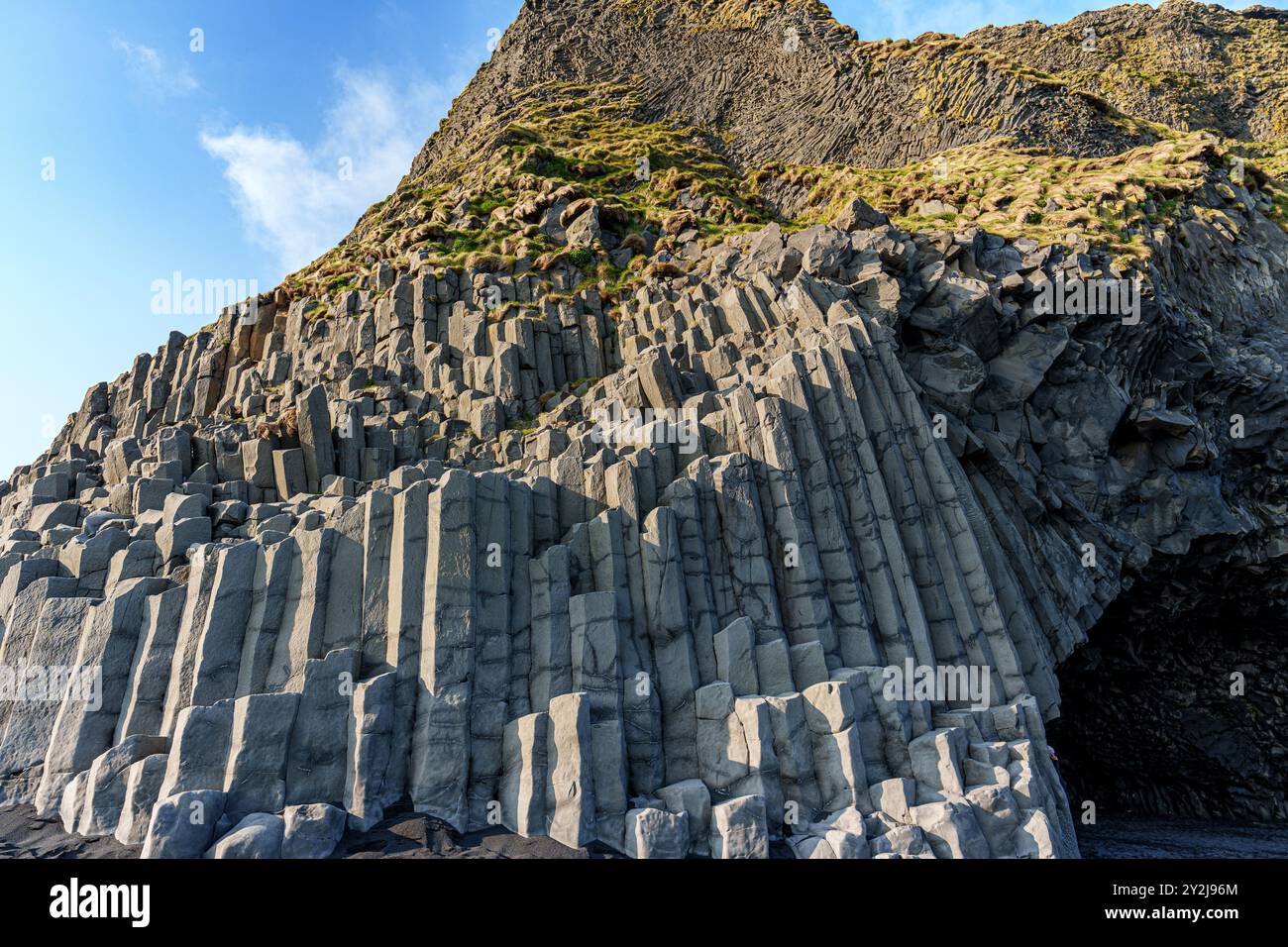 La spettacolare spiaggia di Reynisfjara presenta sabbie vulcaniche nere e torreggianti faraglioni di basalto che si innalzano dal selvaggio Oceano Atlantico in Islanda Foto Stock