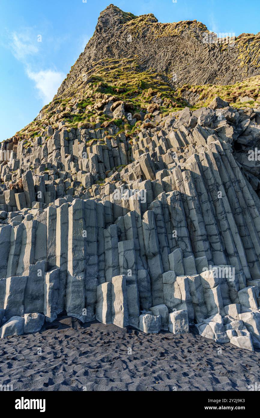 La spettacolare spiaggia di Reynisfjara presenta sabbie vulcaniche nere e torreggianti faraglioni di basalto che si innalzano dal selvaggio Oceano Atlantico in Islanda Foto Stock