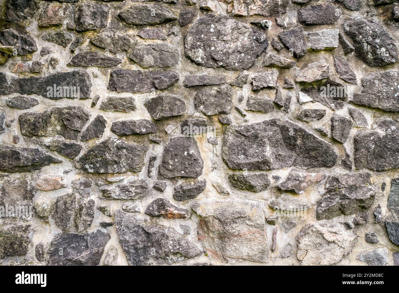 Antico muro rustico in pietra di un complesso medievale di castello. Foto Stock