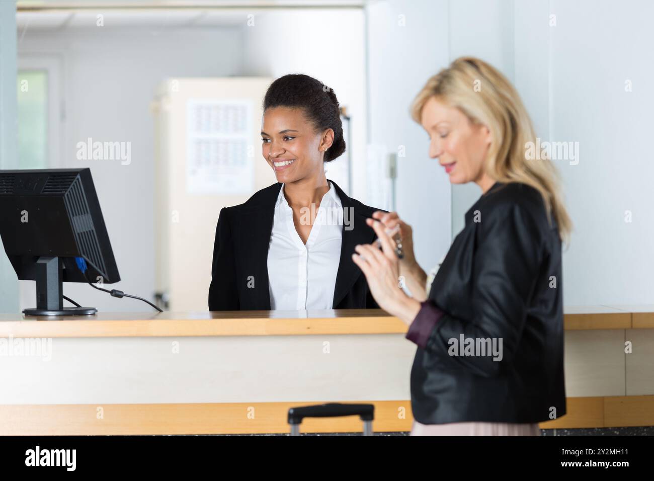 Bella donna presso la reception di un hotel il check in Foto Stock