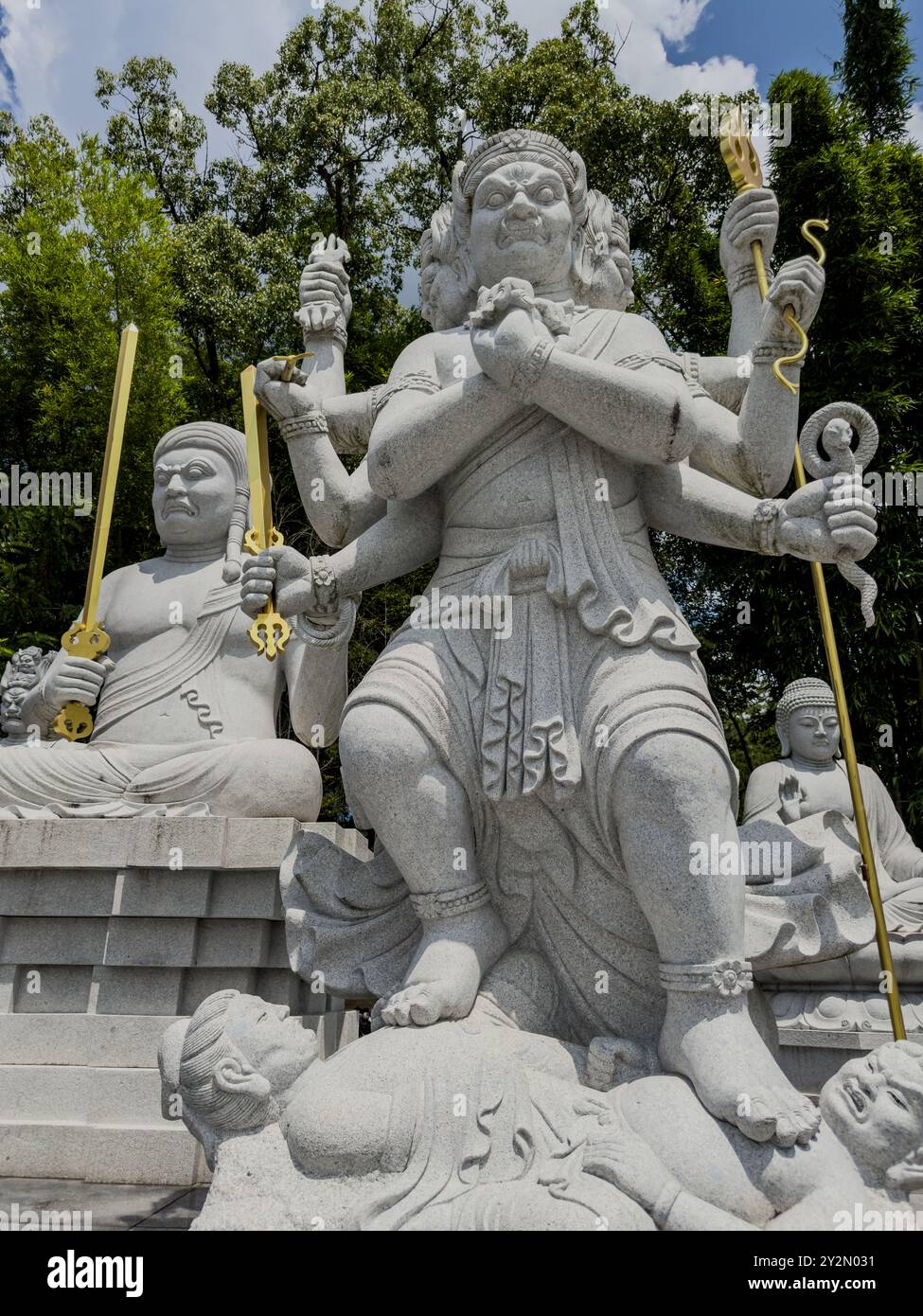 Una feroce statua di divinità multi-armato in piedi su una figura calpestata al tempio di Ishiteji, Matsuyama, Giappone, che simboleggia il potere e la vittoria sul male. Foto Stock