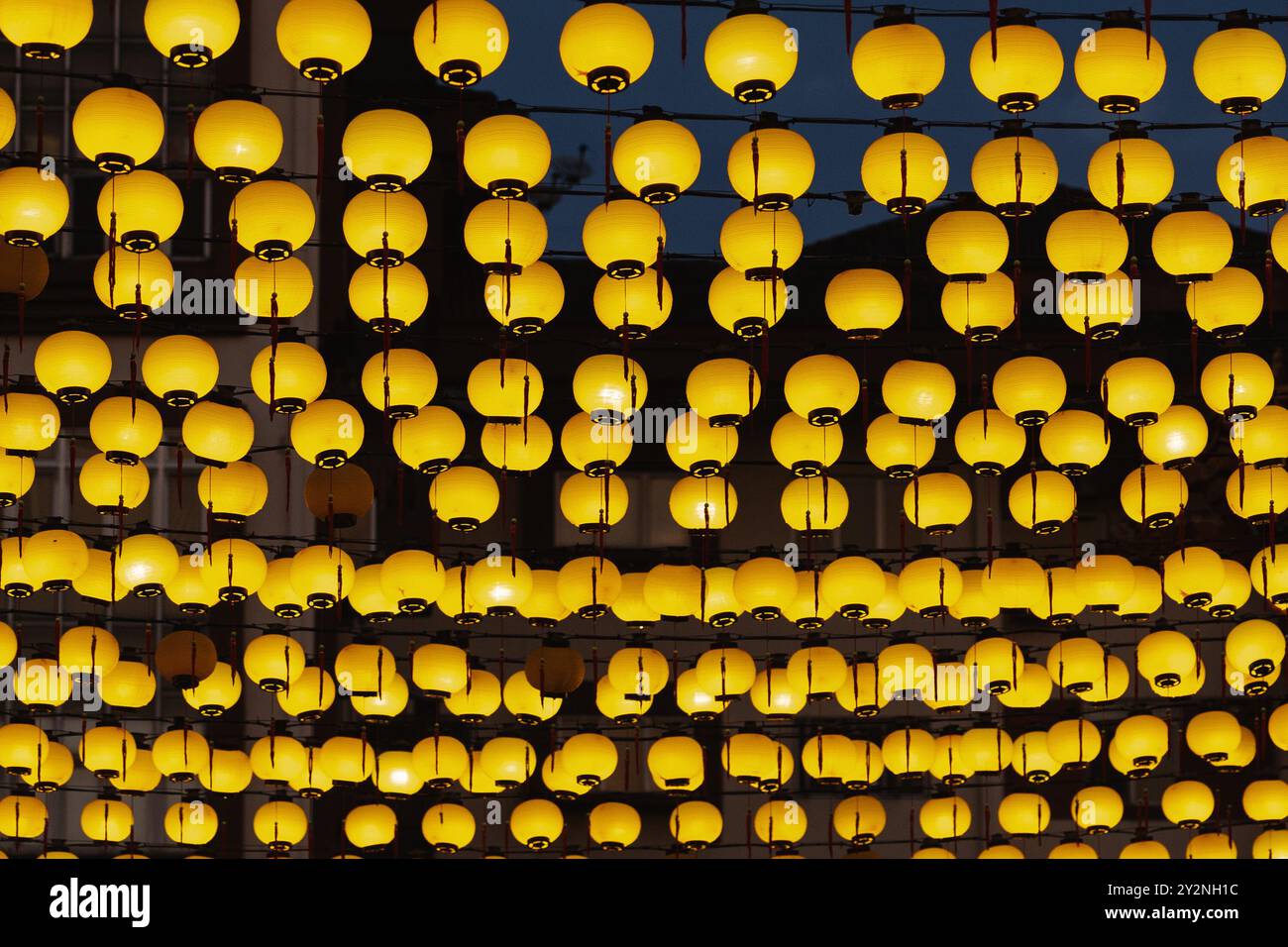 String of Yellow Lanterns (stringa di Lanterne gialle): Un primo piano di una serie di lanterne gialle incandescenti appese sopra la testa, creando un'atmosfera festosa. Foto Stock