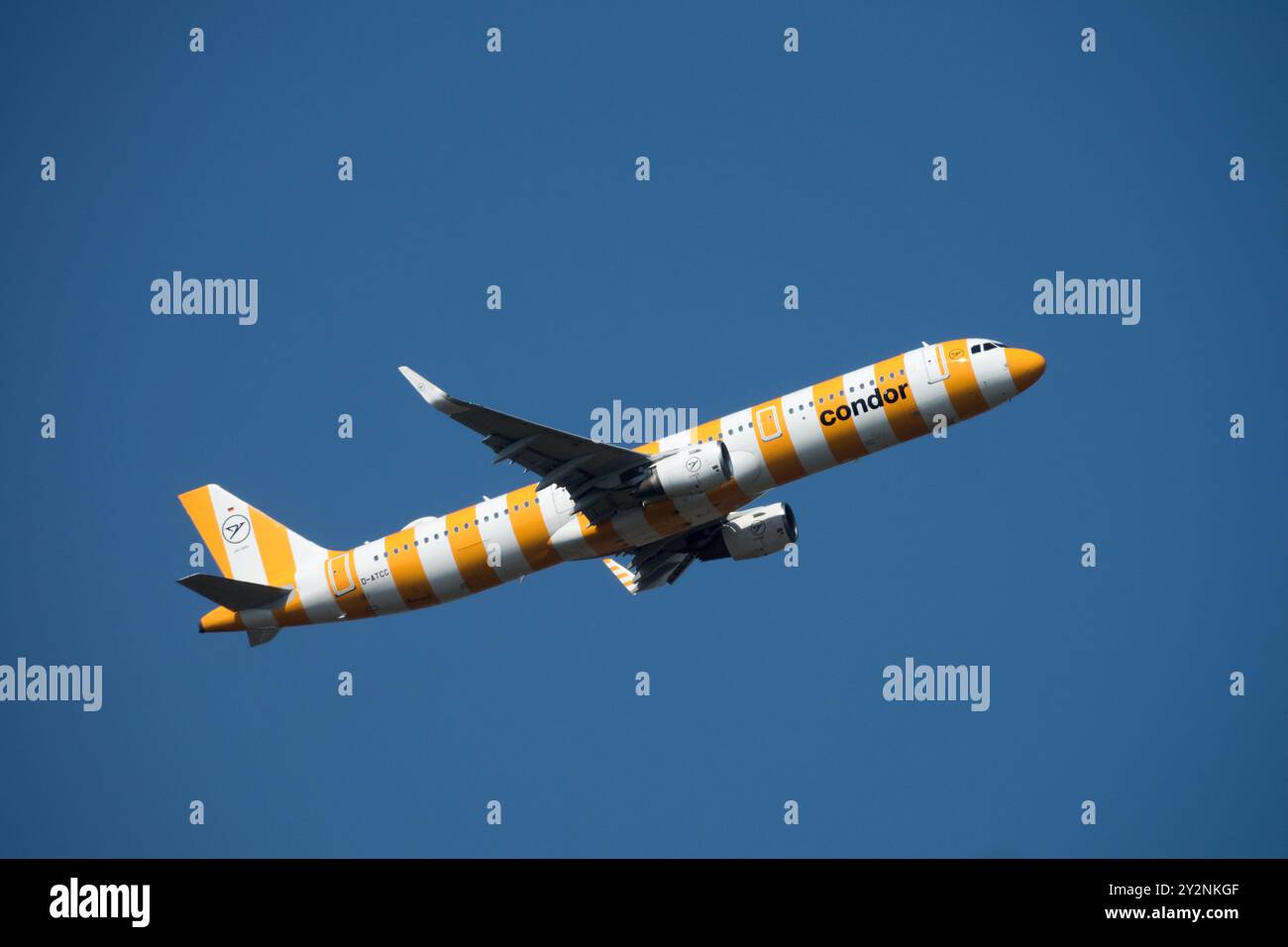 Un aeroplano commerciale Condor dipinto con strisce arancioni e bianche che vola in un cielo azzurro, Condor Aviation Company, decollo dell'Airbus A321 Foto Stock