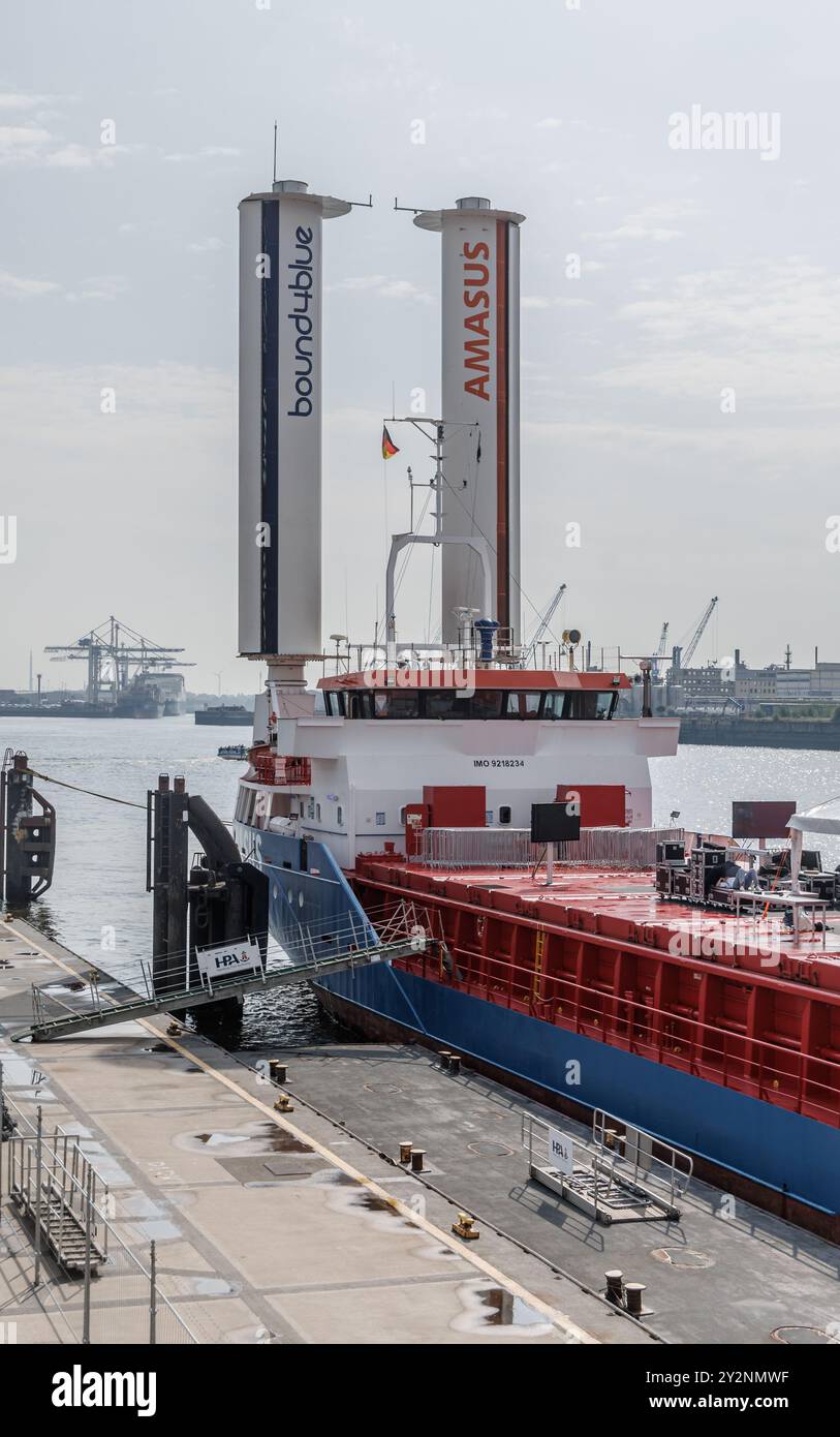 Amburgo, Germania. 12 agosto 2024. La nave da carico generale Eems Traveller, dotata di vele di aspirazione, è ormeggiata nel porto di Amburgo. Le vele di aspirazione hanno lo scopo di ridurre i costi del carburante e le emissioni annue di CO2 della nave da 2.850 dwt fino al 30% sulle rotte commerciali favorevoli. Credito: Markus Scholz/dpa/Alamy Live News Foto Stock