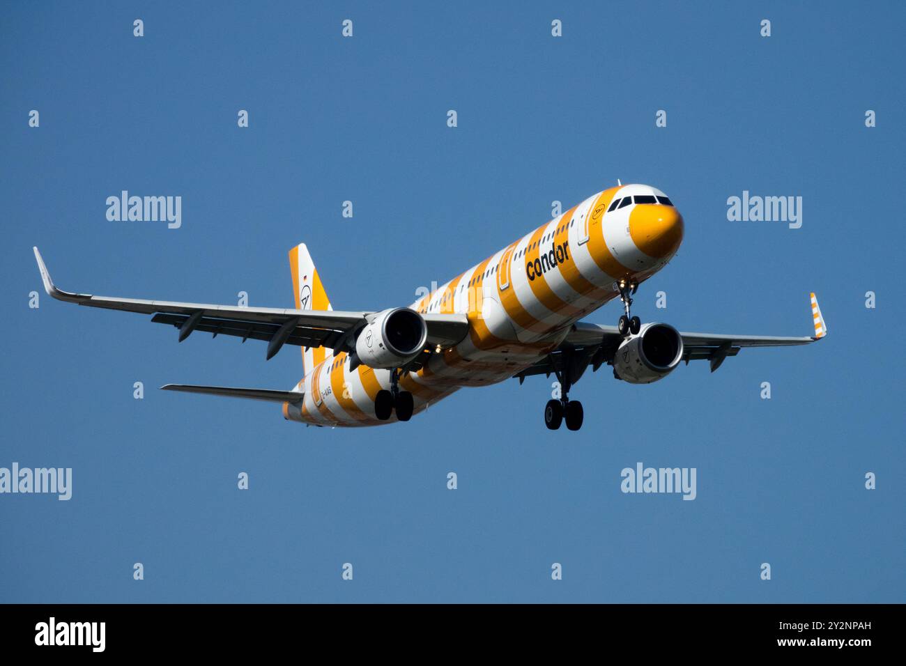 Aereo passeggeri arancione e bianco con design a strisce che si prepara ad atterrare in una giornata chiara e soleggiata Airbus A321 Condor Aviation Company, Lipsia Foto Stock