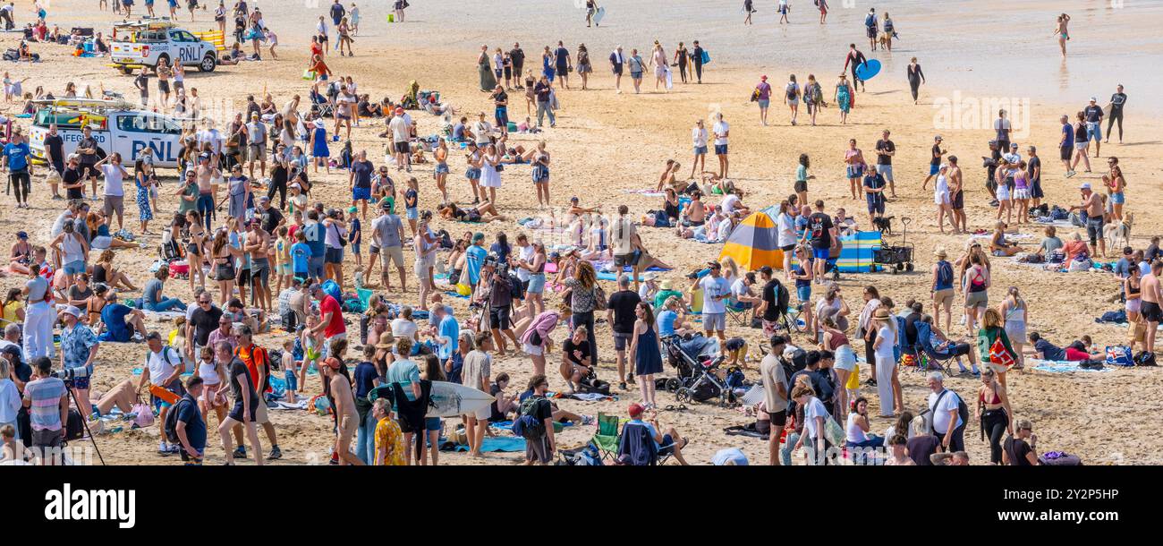 Un'immagine panoramica di turisti che si godono il sole estivo sull'iconica spiaggia Fistral di Newquay, in Cornovaglia, nel Regno Unito. Foto Stock