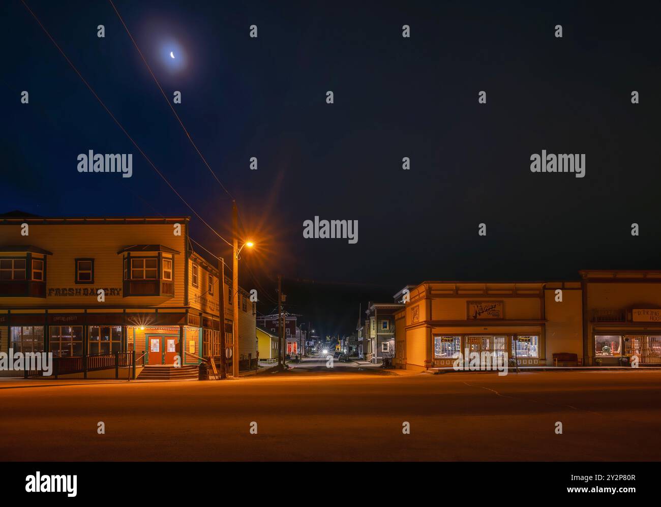 Vista notturna di Front Street a Dawson City Dawson City, Yukon, Canada - 27 agosto 2024: Vista notturna di Front Street con attività commerciali e luna Foto Stock
