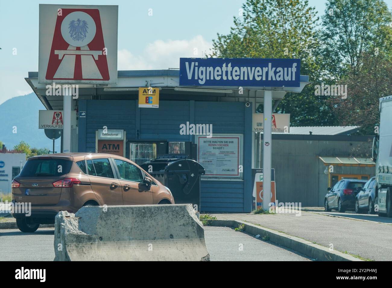 Vignettenverkauf, Autobahn, Mautstelle, Österreich, Vignettenpflicht, Verkehrskontrolle, Reisende, PKW, LKW, Mautstation, Geldautomat, Raststätte, Autobahngebühren, Straßennetz, Verkehrssicherheit, Grenzkontrolle, Infrastruktur, Mautsystem, Straßenverkehr, Kennzeichenpflicht, Reisekosten, Mobilität, Vignettenshop, Straßenbenutzungsgebühr, Reisewarnung, Fahrzeugkontrolle, Einreisebestimmungen, Verkehrsdienstleistungen, Verkehrsgesetz, Pkw-Maut, Verkehrsrecht. *** Vignette sale, superstrada, casello, Austria, obbligo di vignetta, controllo del traffico, viaggiatori, auto, camion, casello, ATM, servizio Foto Stock