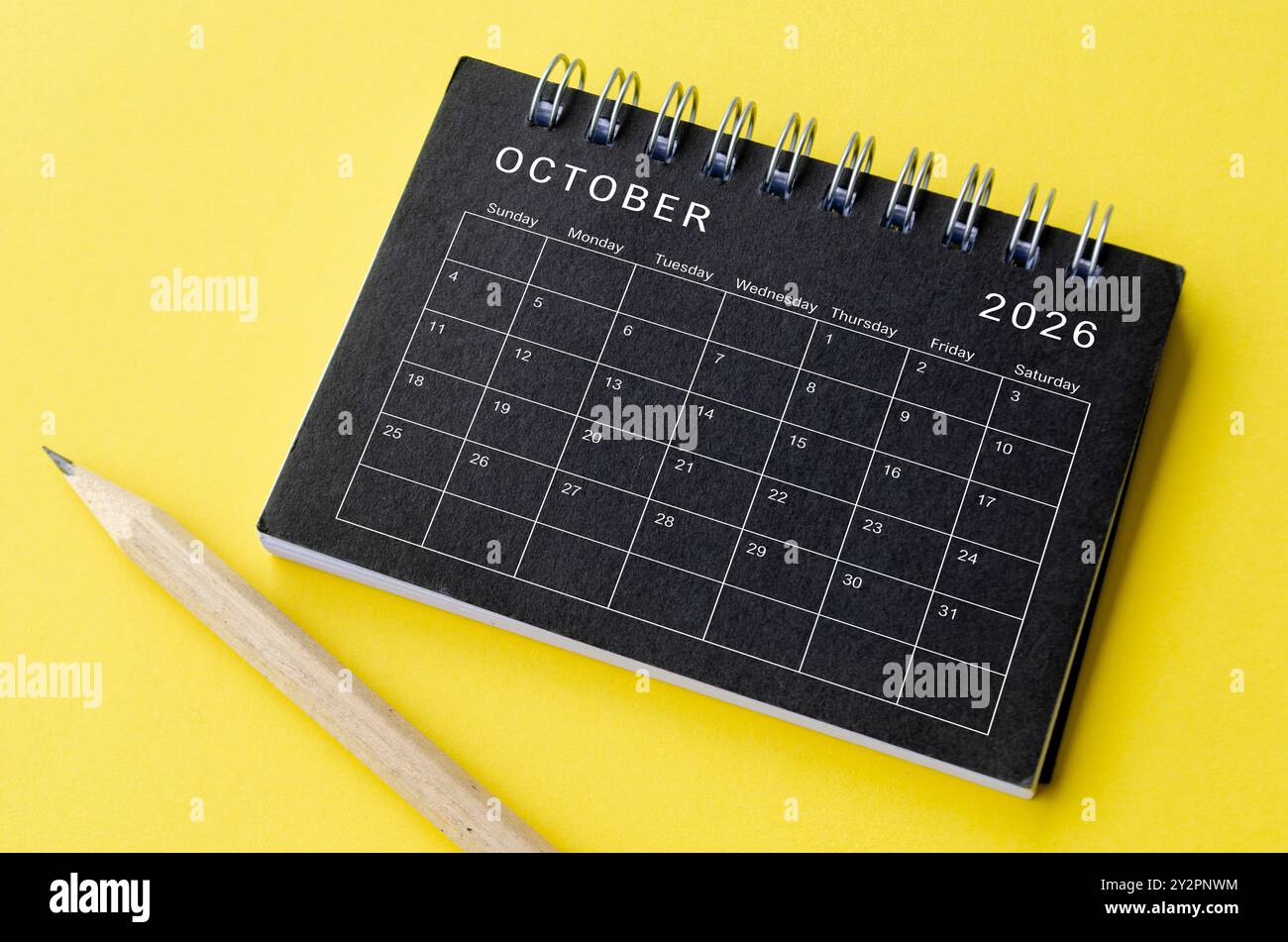 Vista dall'alto del calendario di dicembre 2026 su blocco note nero con sfondo giallo. Concetto di calendario. Foto Stock
