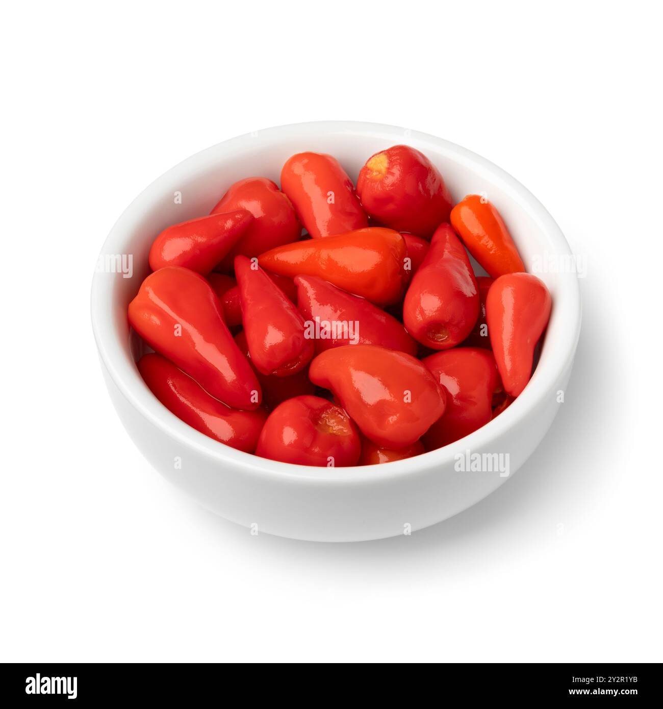 Ciotola con minuscoli peperoni rossi messicani in salamoia isolata su sfondo bianco da vicino Foto Stock