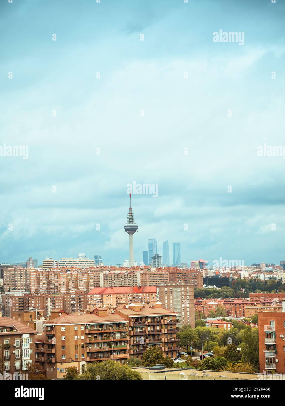 Affacciato sul vivace paesaggio urbano di Madrid, questa fotografia cattura la densa architettura urbana accanto alla famosa Torreespana e alle quattro torri Foto Stock