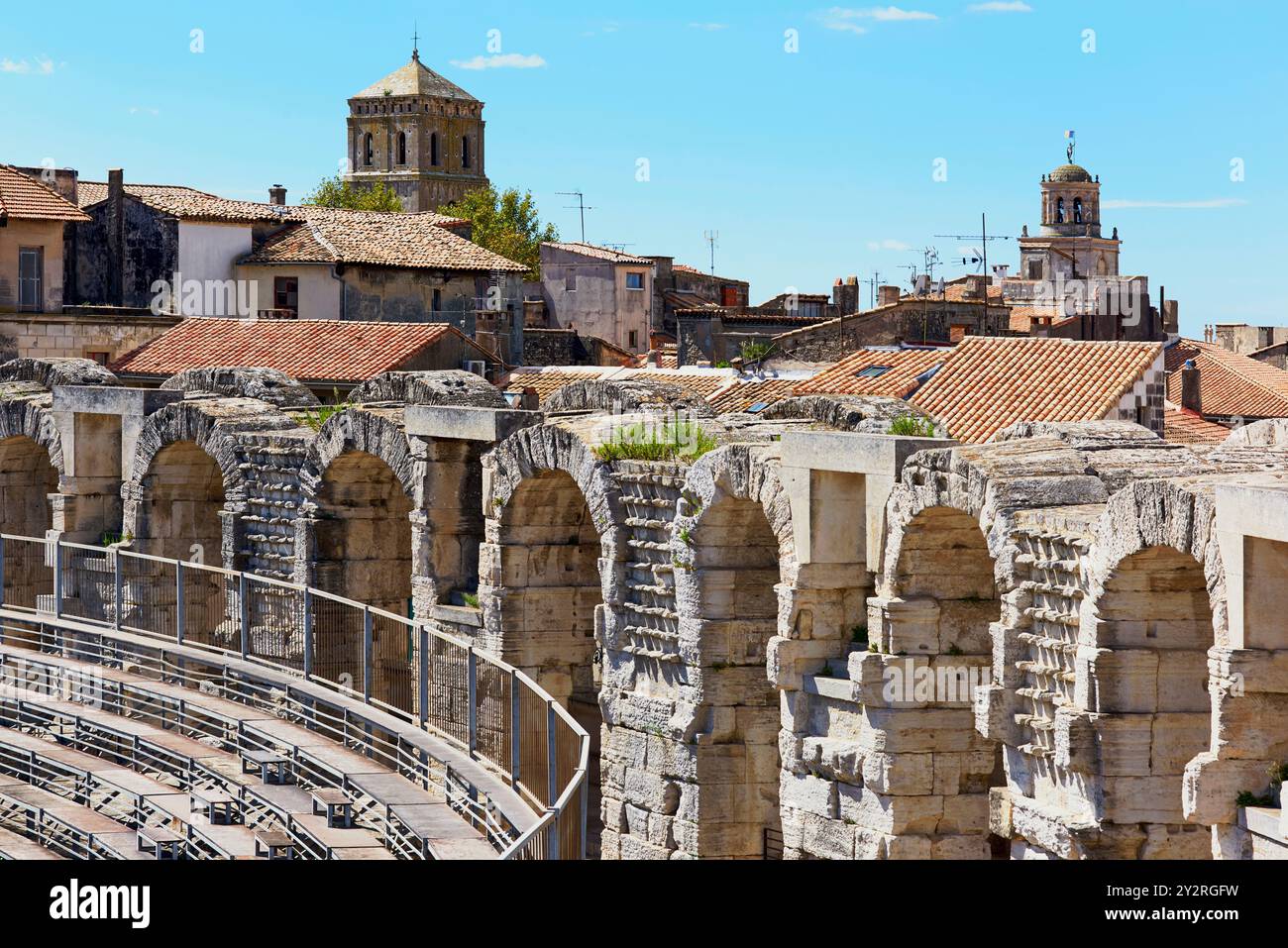 L'interno dell'anfiteatro romano di Arles, Provenza, Francia, guarda verso la torre della chiesa di San Trofeo sui tetti Foto Stock
