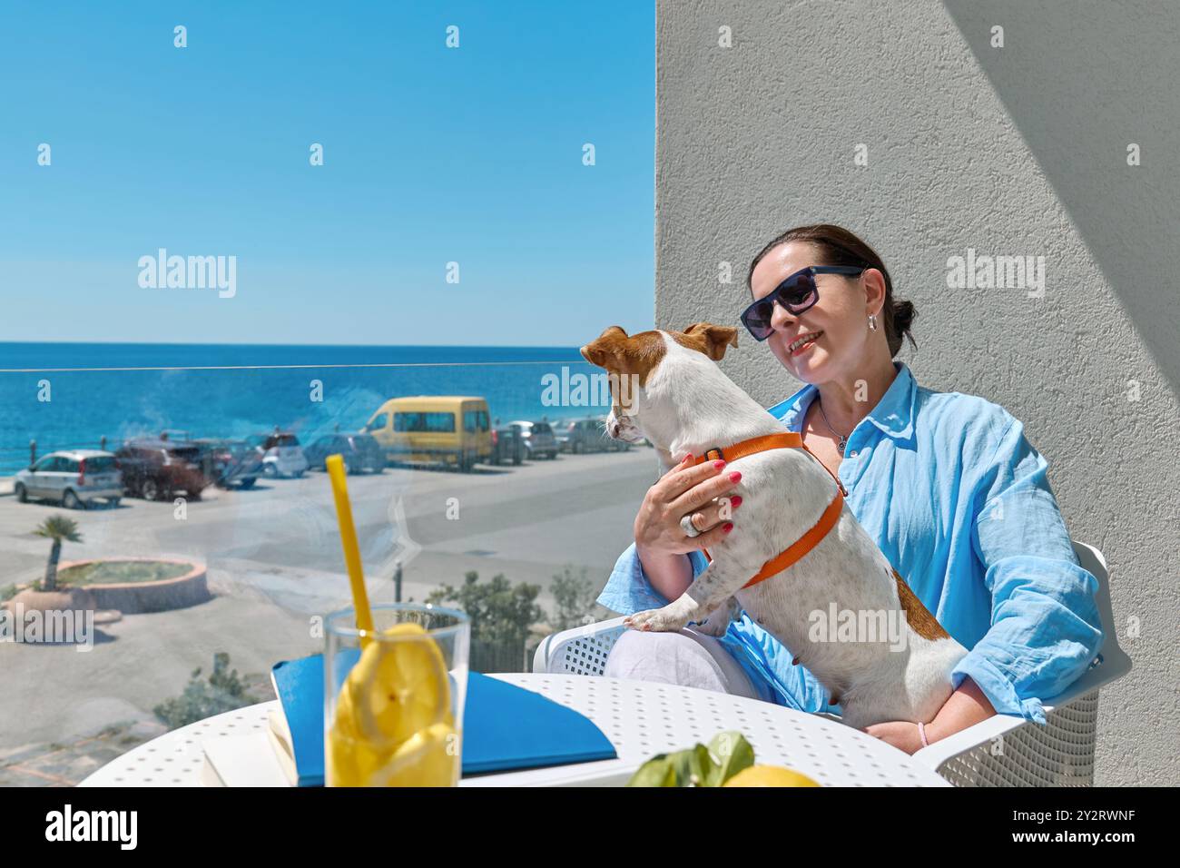 La donna e il suo animale domestico Jack Russell Terrier comunicano nel balcone dell'hotel. Bella donna europea di mezza età e il suo cane passano del tempo insieme. Cane f Foto Stock La donna e il suo animale domestico Jack Russell Terrier comunicano nel balcone dell'hotel. Bella donna europea di mezza età e il suo cane passano del tempo insieme. Cane f Foto Stock