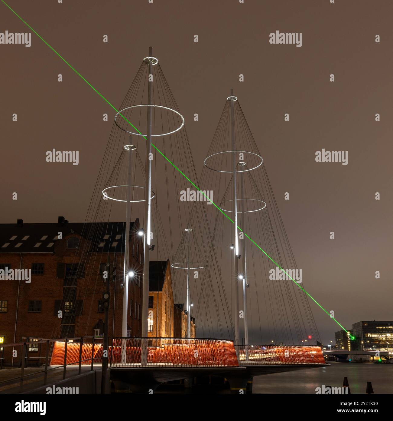 Le luci verdi del laser illuminano il cielo notturno di un ponte Foto Stock