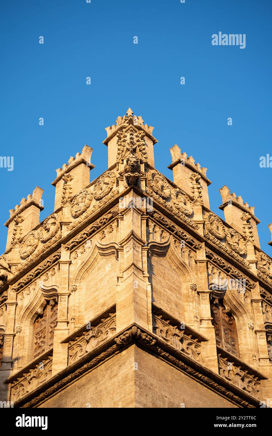 Una vista mozzafiato cattura l'angolo di uno storico edificio in pietra sotto un cielo blu infinitamente vibrante a Valencia, Spagna Foto Stock
